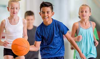 Boys and girls playing indoor basketball